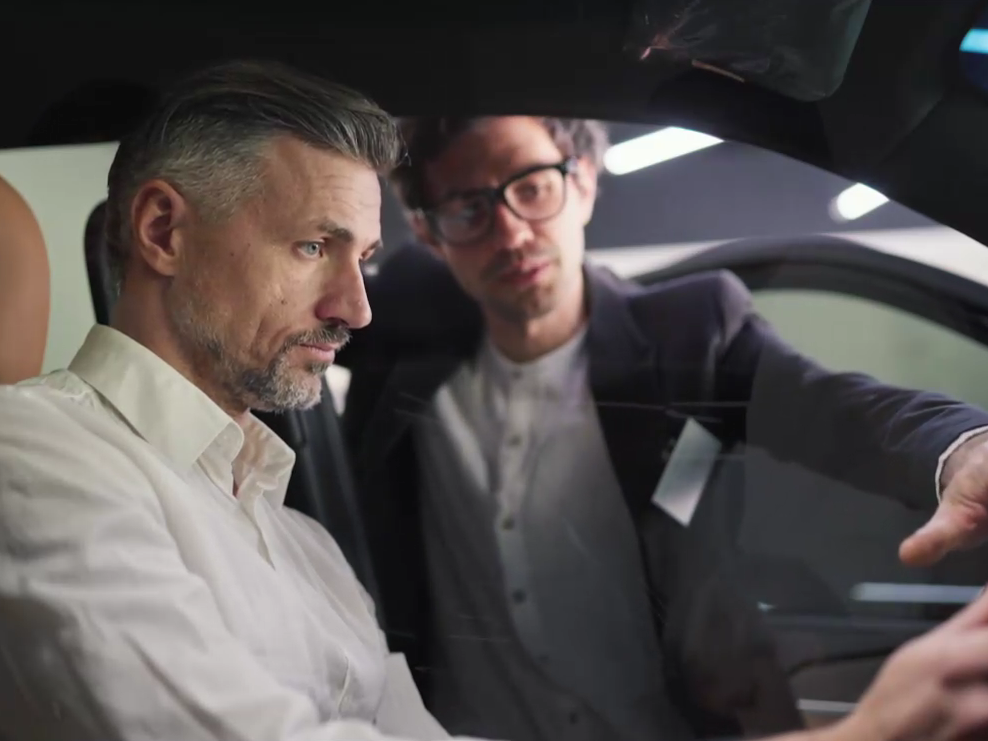 Prospective customer examining car interior in dealer showroom