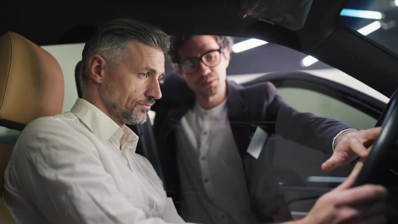 Prospective customer examining car interior in dealer showroom